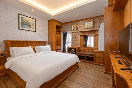 a bedroom with a large bed and a desk at Twelve 8 Boutique House in Phuket Town