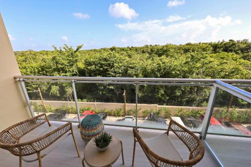 a balcony with two chairs and a table on a balcony at 404-C Luxurious Apartment 5 Minutes from the Beach in La Laguna