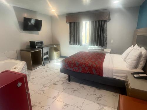 a hotel room with a bed and a desk at Travel Inn Motel in Anaheim