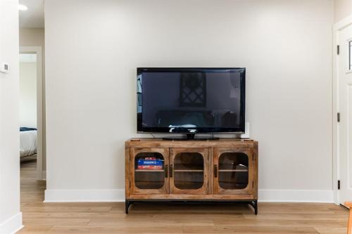 a tv sitting on top of a wooden cabinet at End Zone Escape - 2BR house 1 mile to ND Stadium! in South Bend
