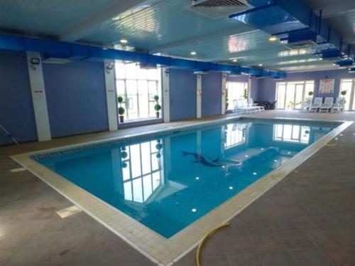 a large swimming pool in a large room at Ocean Breeze Hideaway 2 Bed Pet Friendly Static Caravan In Clarach Bay in Aberystwyth