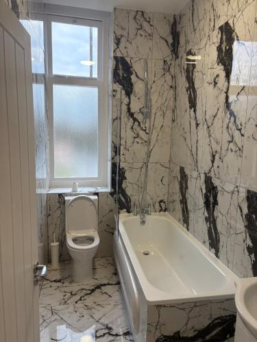 a bathroom with a tub and a toilet and a window at The Lookout in Cove