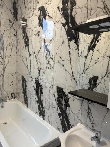 a bathroom with a sink and a black and white marble wall at The Lookout in Cove
