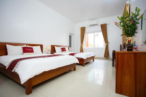 a bedroom with two beds and a window at Hòa Bình Tam Đảo Hotel in Tam Ðảo