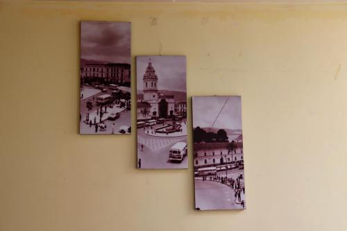 a group of four pictures hanging on a wall at Hostal History in Quito