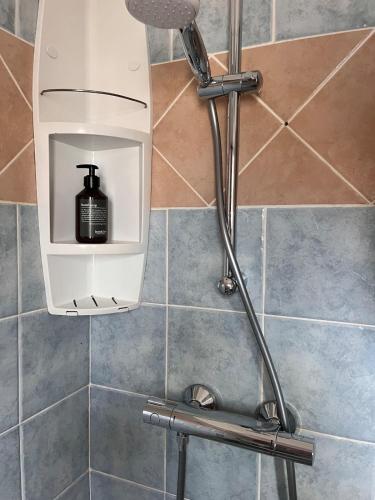 a shower with a black soap dispenser in a bathroom at Beachapartment fully serviced in Sal Rei