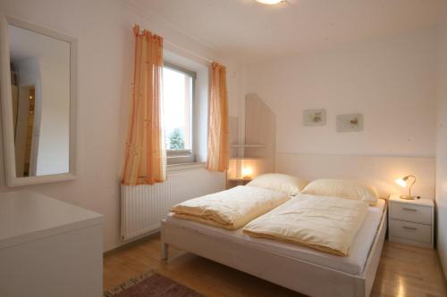 um quarto branco com uma cama e uma janela em Appartements Schwaiger by Schladming-Appartements em Schladming