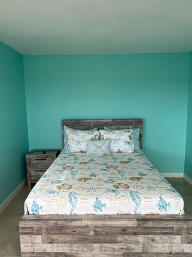 a bedroom with a bed with a blue wall at Anna's Hidden Gem Waterfront in Farmerʼs Hill