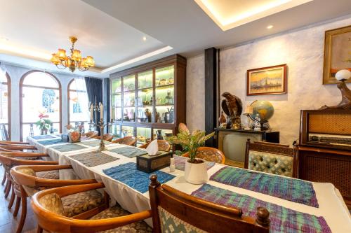 a dining room with a long table and chairs at Twelve 8 Boutique House in Phuket Town