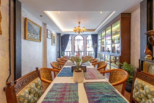 a dining room with a long table and chairs at Twelve 8 Boutique House in Phuket Town