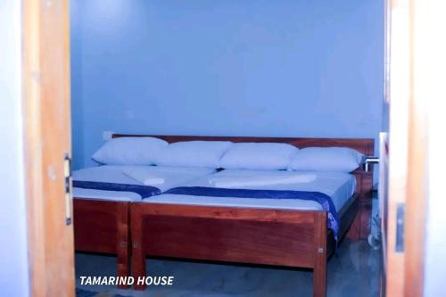 a blue room with a bed with blue sheets and pillows at Tamarind Breeze House in Mariakani