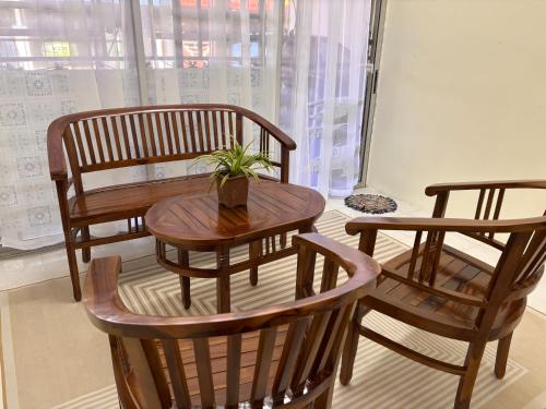 a wooden table and chairs with a potted plant on it at Homestay Selesa Taman Lembah Bujang in Bedung