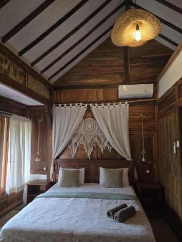 a bedroom with a large bed with a canopy at Little Elephant Cottage in Gili Trawangan