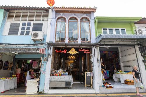 a woman standing in front of a store at Twelve 8 Boutique House in Phuket Town