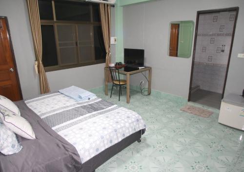 a bedroom with a bed and a desk with a computer at Le Saint Germain in Hua Hin