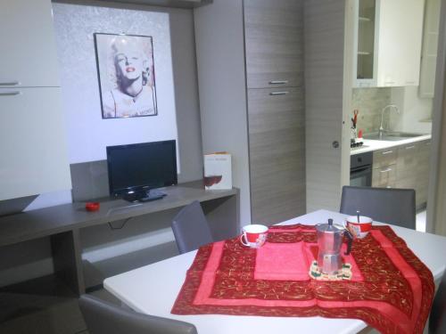 a kitchen with a table with a red blanket on it at M&D Appartamenti in Trapani