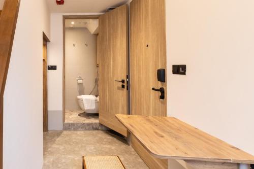 a bathroom with a wooden door and a toilet at Heritage Collection on Victoria - Mobile App Check-In in Singapore