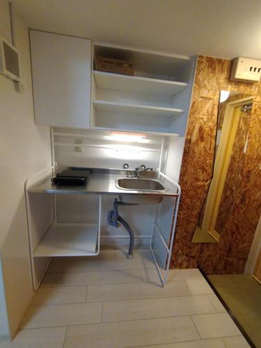 a small kitchen with a sink and an open refrigerator at 下町の穴場 キッチン完備 長期滞在に最適なお部屋 Rapyuta monthly apartment in Kyoto