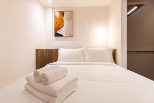 a bedroom with a white bed with towels on it at Heritage Collection on Victoria - Mobile App Check-In in Singapore