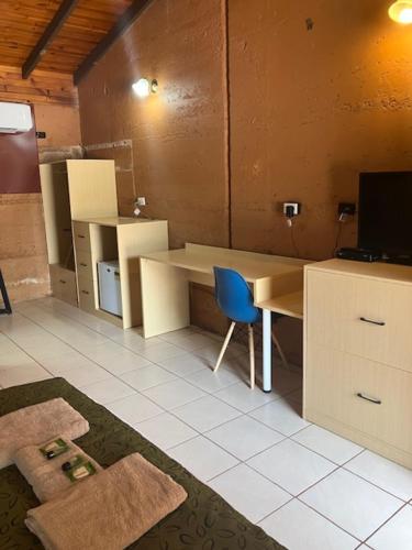 a room with a desk and a blue chair at Territory Manor Motel & Caravan Park in Mataranka