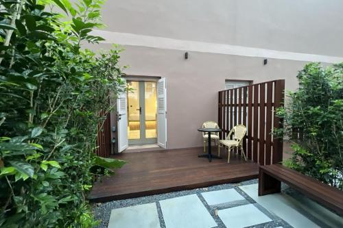 a patio with a table and chairs and plants at Heritage Collection on Victoria - Mobile App Check-In in Singapore