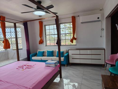 a bedroom with a bed and a couch at Da Pink And White Palace in Nassau