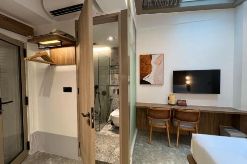 a room with a bathroom with a shower and a table at Heritage Collection on Victoria - Mobile App Check-In in Singapore