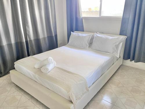 a bed with white sheets and a towel on it at Charming Chevron Island Haven- Dog-Friendly Retreat Right on Main River in Gold Coast