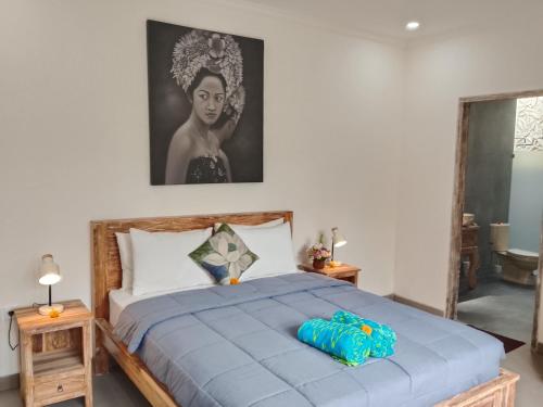 Un dormitorio con una cama grande con un edredón azul. en Villa Tenang, en Ubud