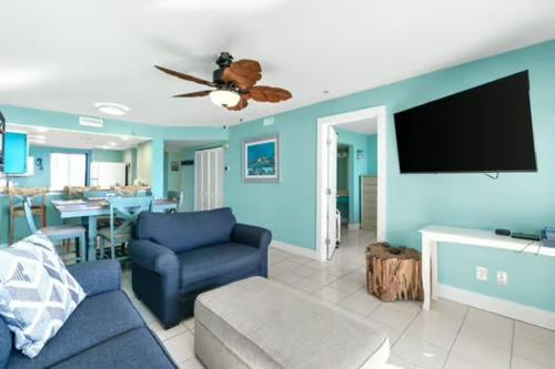 a living room with a couch and a flat screen tv at Commodore 202 - Thomas Drive Paradise in Panama City Beach