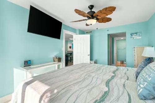 a bedroom with a large bed with a ceiling fan at Commodore 202 - Thomas Drive Paradise in Panama City Beach