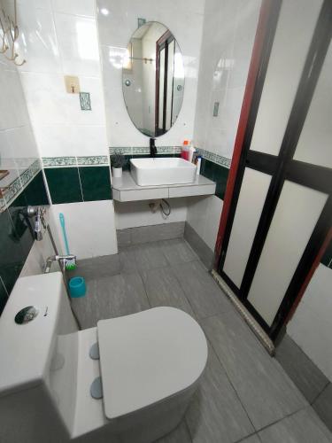 a bathroom with a toilet and a sink and a mirror at Teaz Apartment at Glory Beach Resort in Port Dickson
