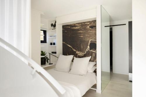 a bedroom with a white bed with white pillows at Little Darling in Sydney