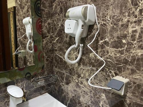 um banheiro com um telefone em uma parede de pedra em Golden Pyramids View Inn em Cairo