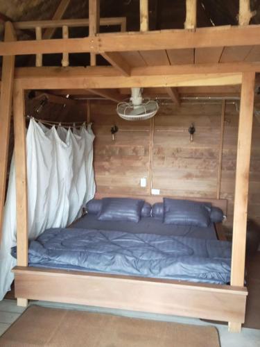 a bed in a wooden room with a mattress at FANDEE ISLAND Treehouses & Ziplines - Tad Lo, Bolaven Loop Pakse in Ban Kiangtat