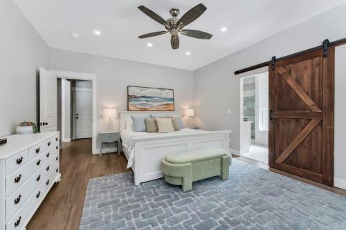 a white bedroom with a bed and a ceiling fan at Large Flagstaff Home Near Violas with Hot Tub in Flagstaff