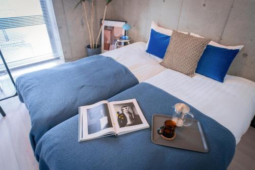 a bed with two pictures and a tray on it at Ueno Grand Maison Hotel in Tokyo