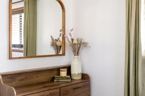a mirror and a vase with flowers on a dresser at The Pine Perch in Munds Park