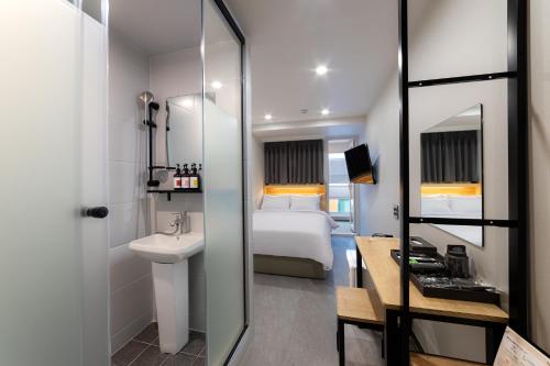 a hotel room with a bathroom with a bed and a sink at Stayz437 Jongno in Seoul