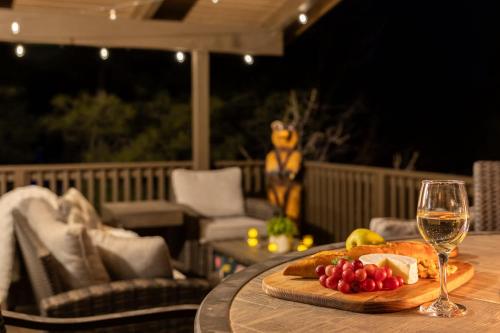a table with a glass of wine and a plate of fruit at The Pine Perch in Munds Park