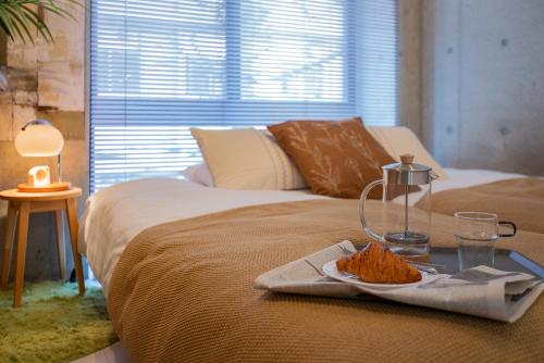 a bed with a tray with a plate of food on it at Ueno Grand Maison Hotel in Tokyo