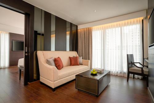 a living room with a couch and a table at Mövenpick Hotel Sukhumvit 15 Bangkok in Bangkok