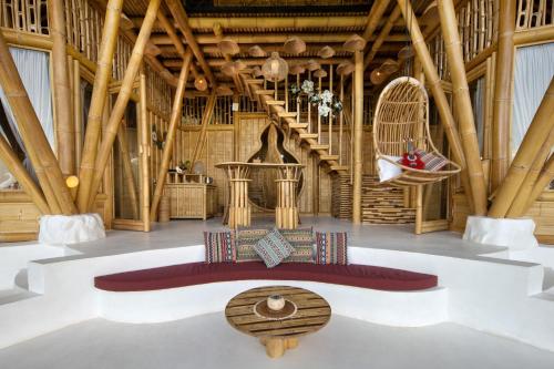 a room with bamboo ceilings and a bench in the middle at Magic Hills Bali - Eco Luxury Adventure in Karangasem