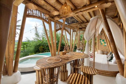 a pavilion with a table and chairs next to a pool at Magic Hills Bali - Eco Luxury Adventure in Karangasem