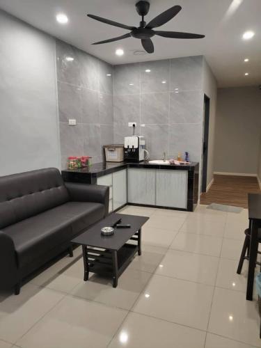 een woonkamer met een bank en een tafel bij T&S Management House in Gua Musang