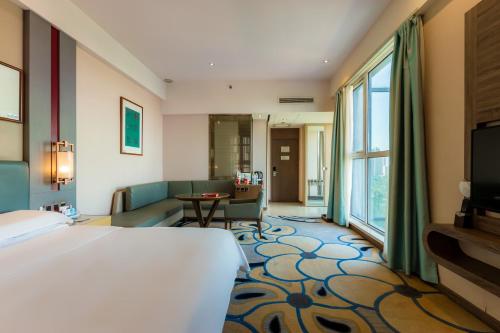 a hotel room with a bed and a living room at 济宁银座佳悦精选酒店 in Jining