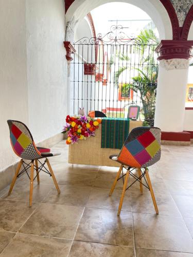 two chairs and a table with flowers in a room at Casa Santo Benito in Atlixco