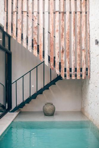 a staircase with a vase sitting next to a pool at Tulum Jungle Luxury Villa -Pvt Pool - Concierge 6A in Tulum