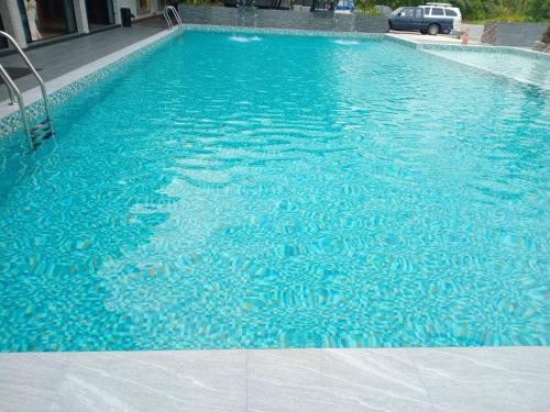 攀牙Le Erawan Phang Nga Hotel的建筑物内蓝色水的游泳池