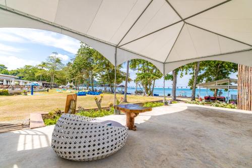 a table and a chair under a large umbrella at BJ & Radisson Sea View Hotel in Ko Yao Yai